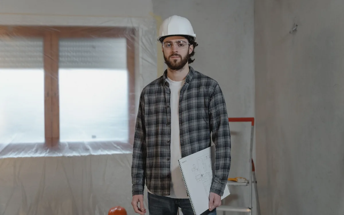 A contractor with a clipboard on a job in progress
